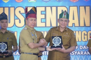 Gubernur Sultra, Andi Sumangerukka saat menyerahkan penghargaan kepada Wali Kota Baubau, H.Yusran Fahim.  Foto Ist