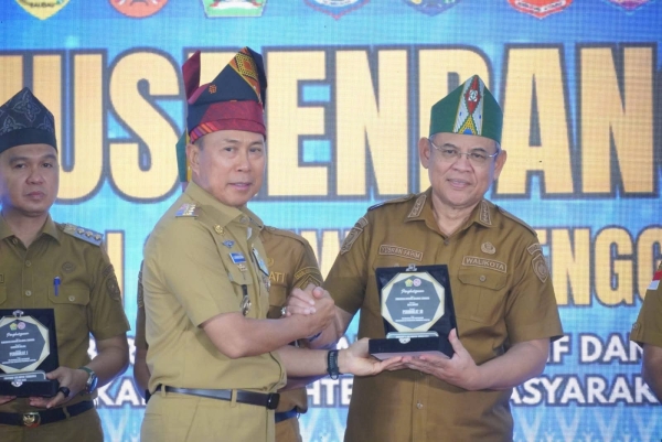 Gubernur Sultra, Andi Sumangerukka saat menyerahkan penghargaan kepada Wali Kota Baubau, H.Yusran Fahim.  Foto Ist